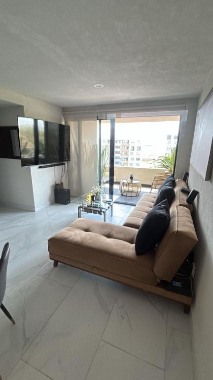 a large couch in a living room with a large window at Santa Fe Dorado Atardecer in Atlacholoaya