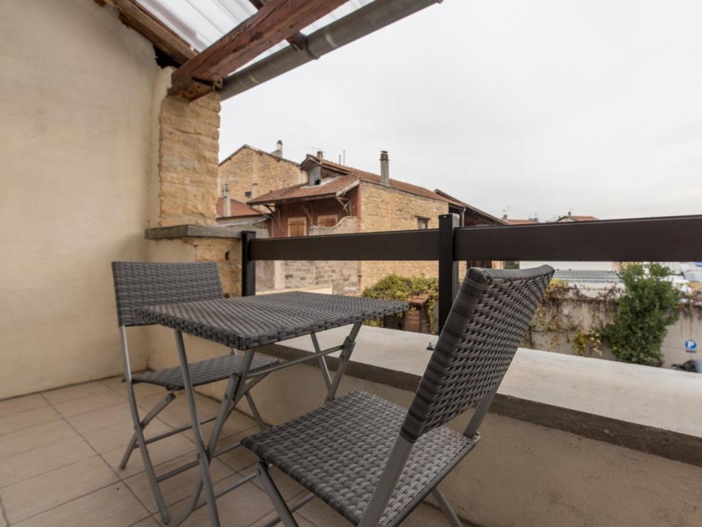 a pair of chairs and a table on a balcony at Appart Hôtel Bourgoin in Bourgoin