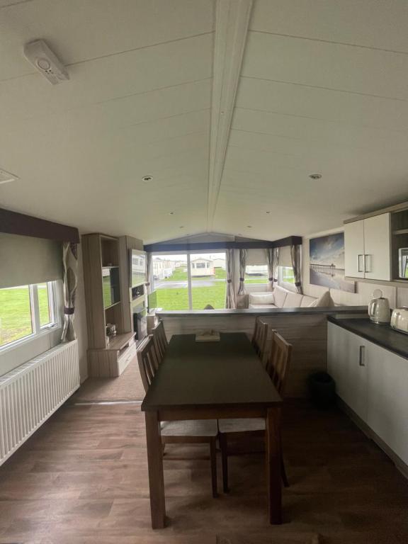 a kitchen and dining room with a table and chairs at Shells at Sandylands in Stevenston