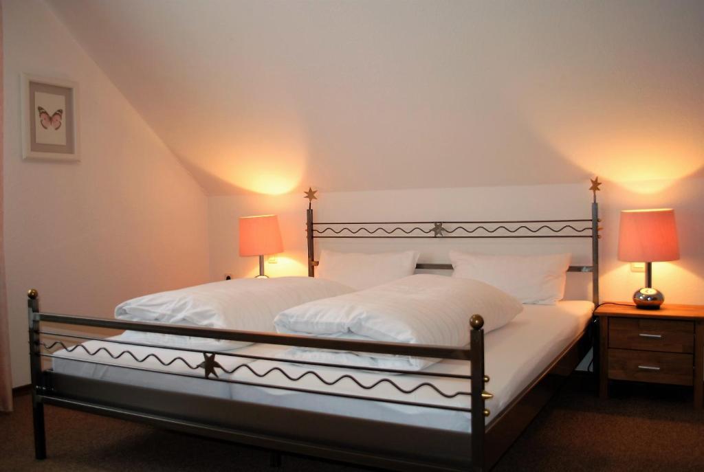 twee bedden in een slaapkamer met twee lampen op tafels bij Ferienwohnung Sonne in Bad Windsheim
