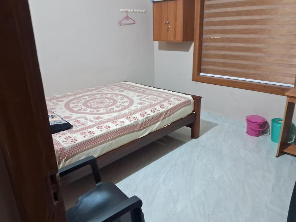 a small bed in a room with a window at Sree durga Villa Homestay in Kodoth