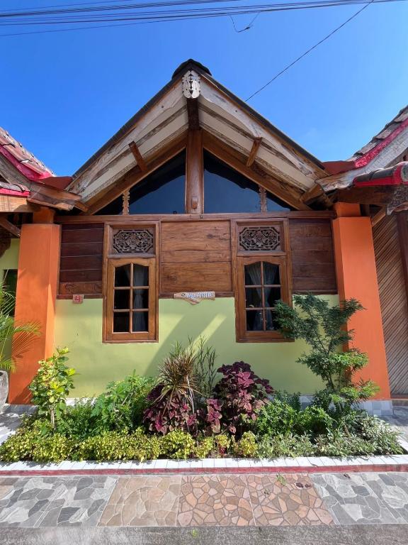 a house with a wooden roof and windows at Amelia Villa in Montongbuwoh