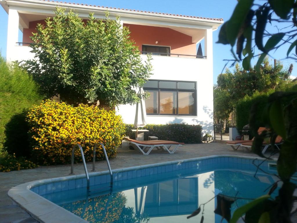 una casa con piscina delante de un edificio en Kissonerga Apartment, en Pafos