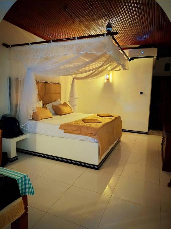 a bedroom with a large bed with a canopy at Lausanne villa in Dharga Town