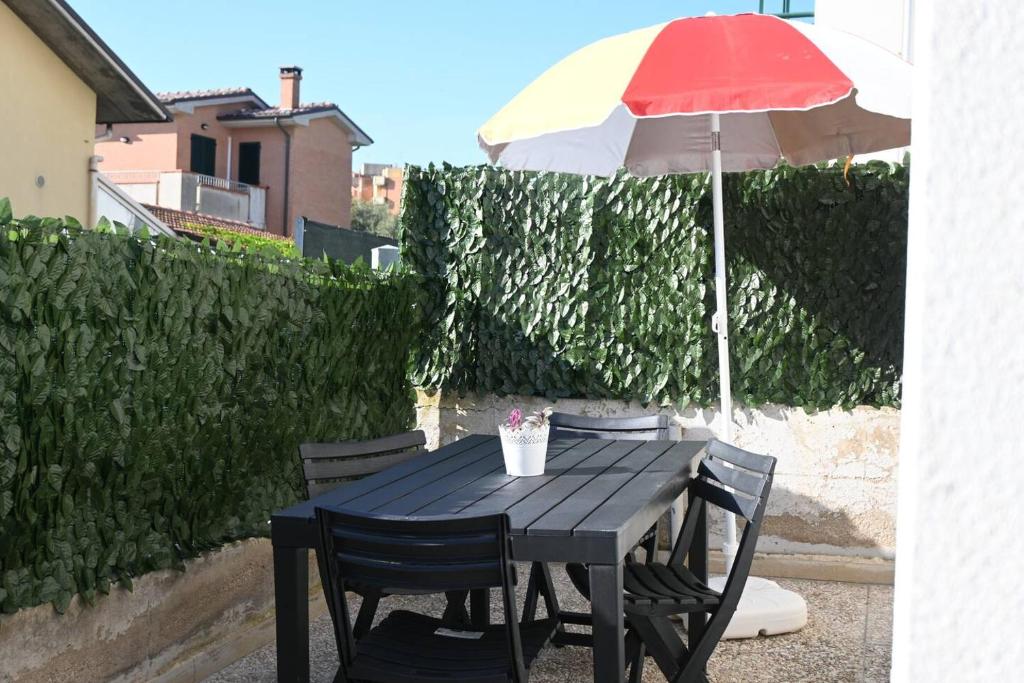 a black table with a red and yellow umbrella at Casa Vacanze Zefiro in Marzocca di Senigallia