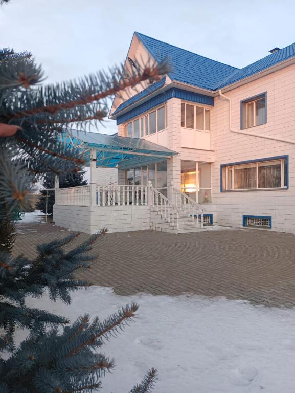 a house with a christmas tree in front of it at Усадьба in Kostanay
