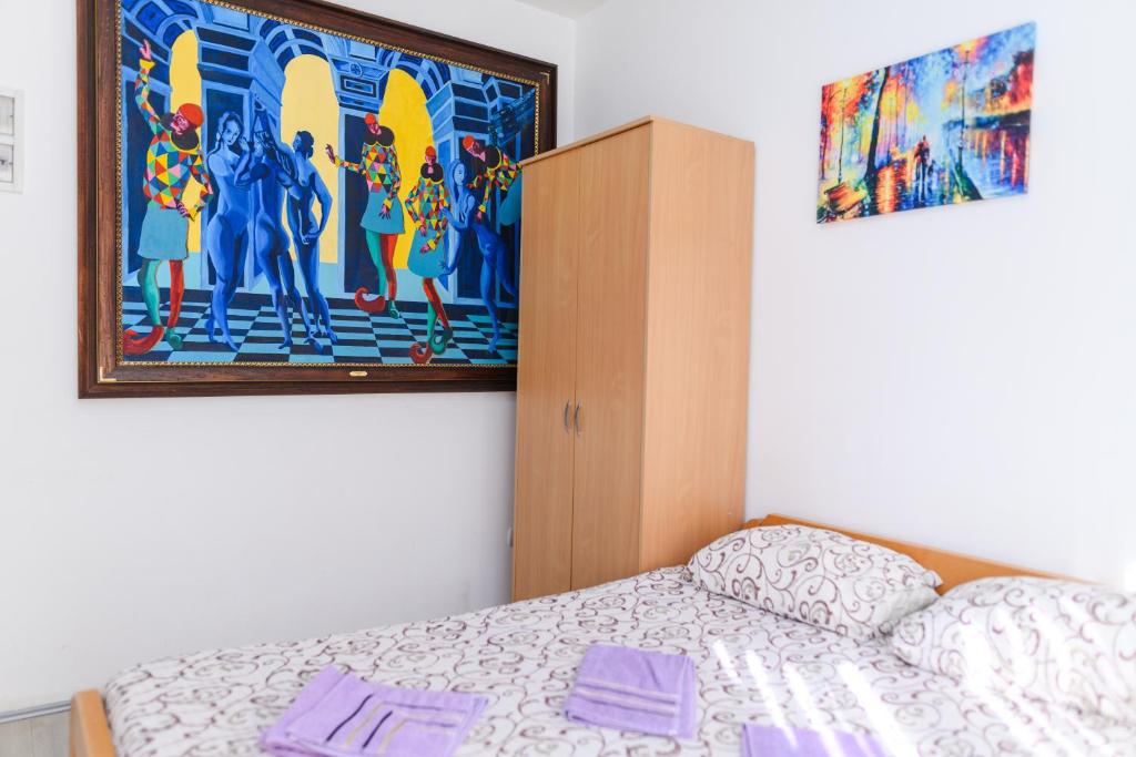 a bedroom with a bed and a painting on the wall at Studio Merlin 2 in Soko Banja
