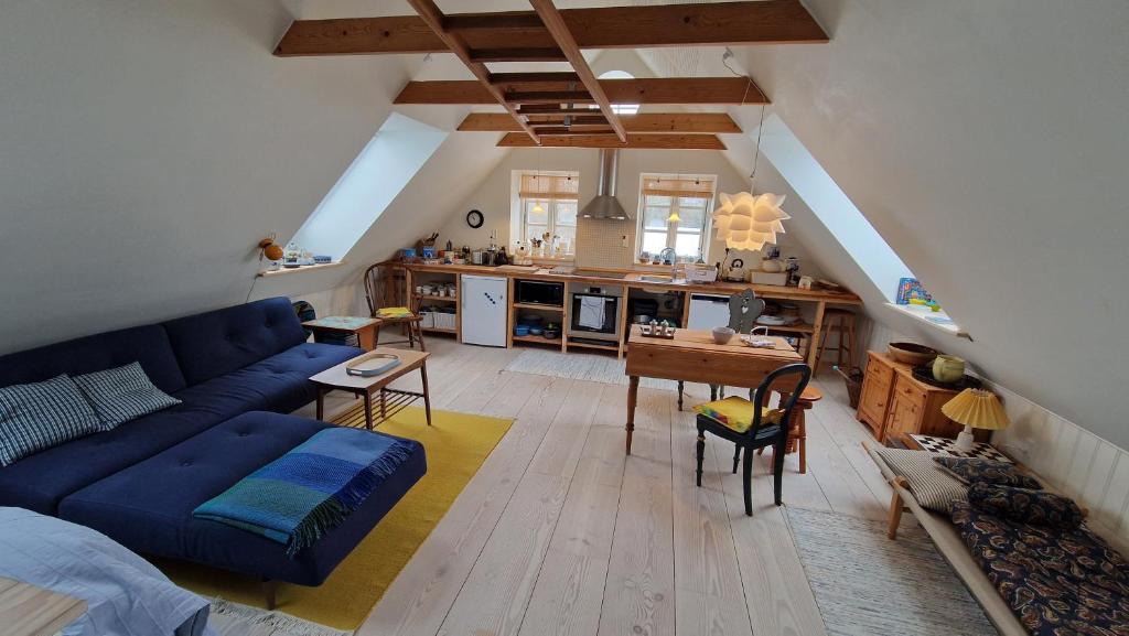 a living room with a blue couch and a kitchen at Lejlighed nær badesø in Årslev