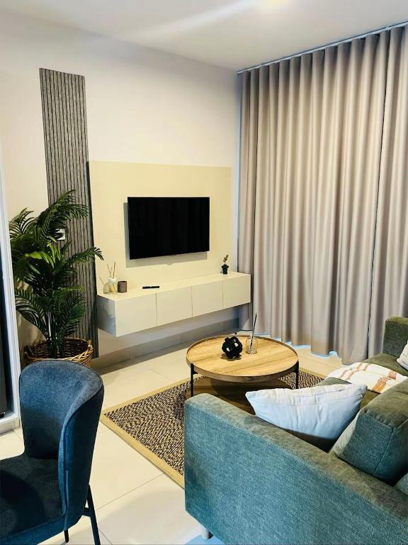 a living room with a couch and a tv at The Kgale Luxe in Gaborone