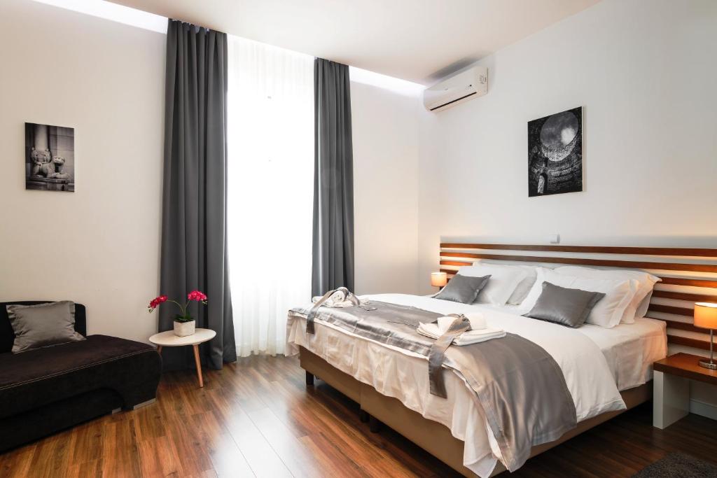 - une chambre avec un grand lit et un canapé dans l'établissement Prima Luxury Rooms, à Split