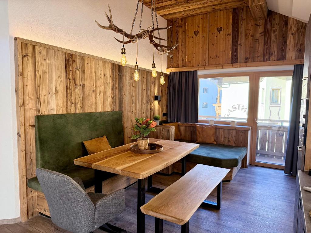a dining room with a wooden table and green chairs at Das Lisal in Zell am Ziller