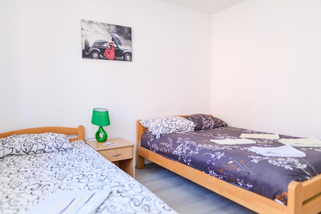 a bedroom with two beds and a lamp on a table at Studio Merlin 4 in Soko Banja