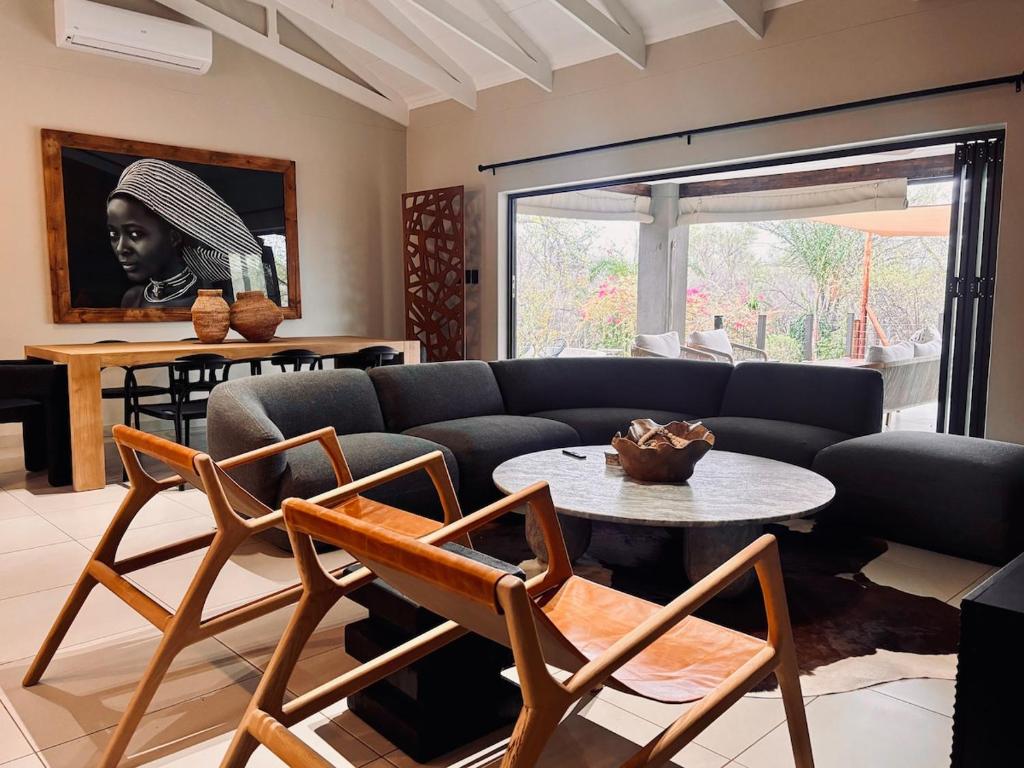 a living room with a couch and a table at Rhula Villa - Stylish Private Safari Villa in Hoedspruit