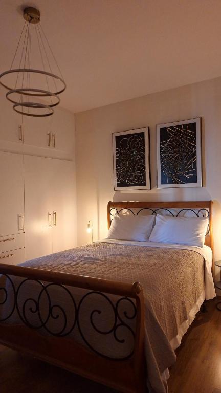 a bedroom with a bed with two pictures on the wall at City Comfort Sparti in Sparta
