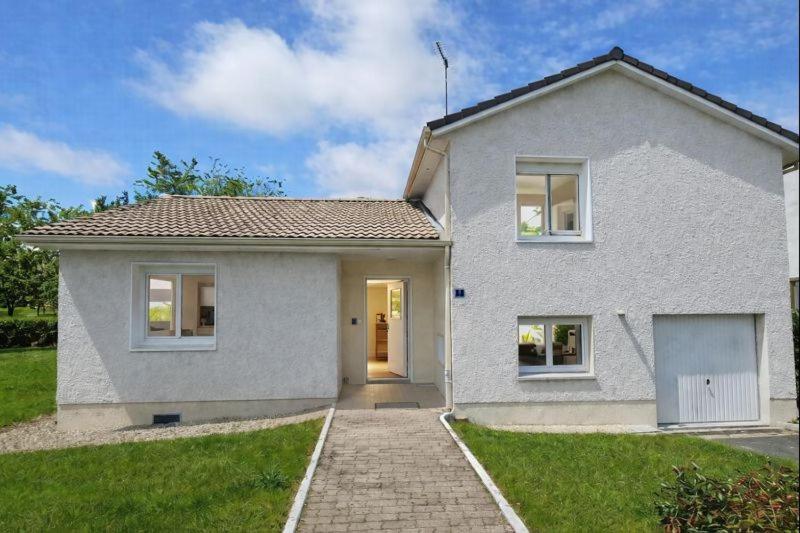 a white house with a pathway in front of it at La Maison du Lac in Montceau-les-Mines