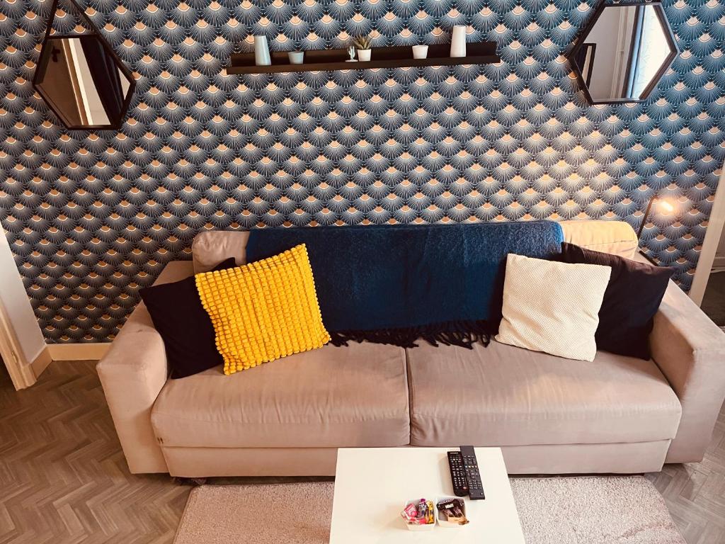 a living room with a brown couch and a wall at Le Bretonneau Ledru Rollin in Tours