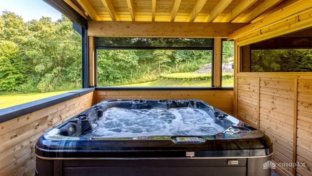 a hot tub in a room with a large window at Mom's Home in Burg-Reuland