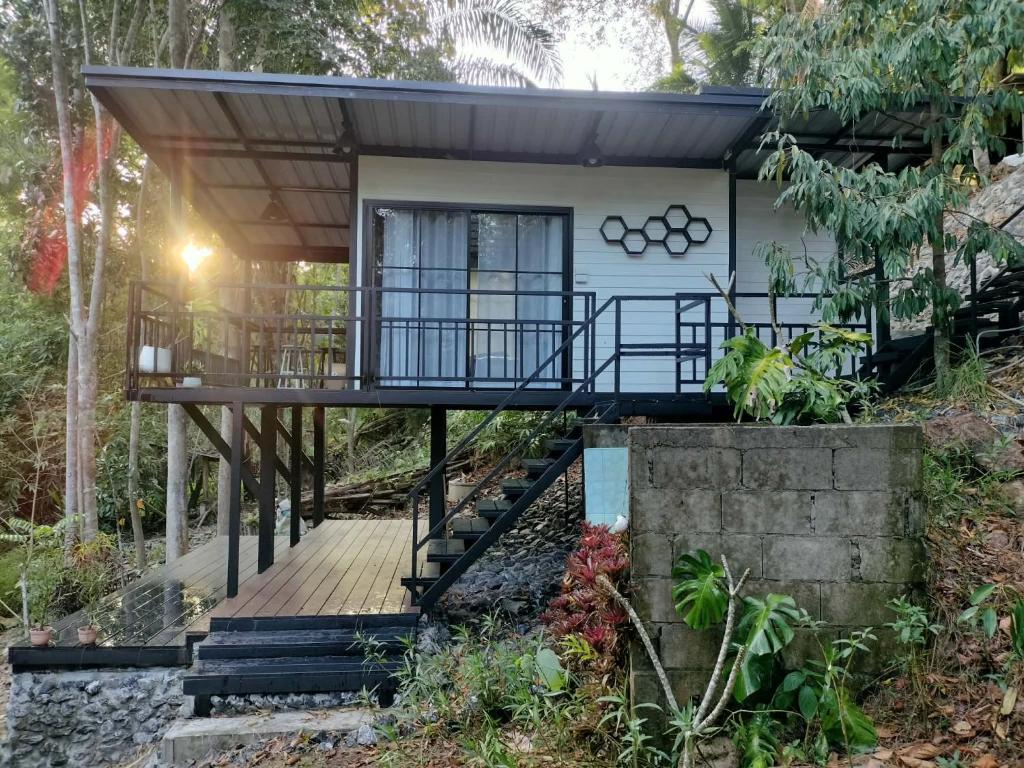 a house in the woods with a wooden walkway at Ingphai Homestay in Suratthani