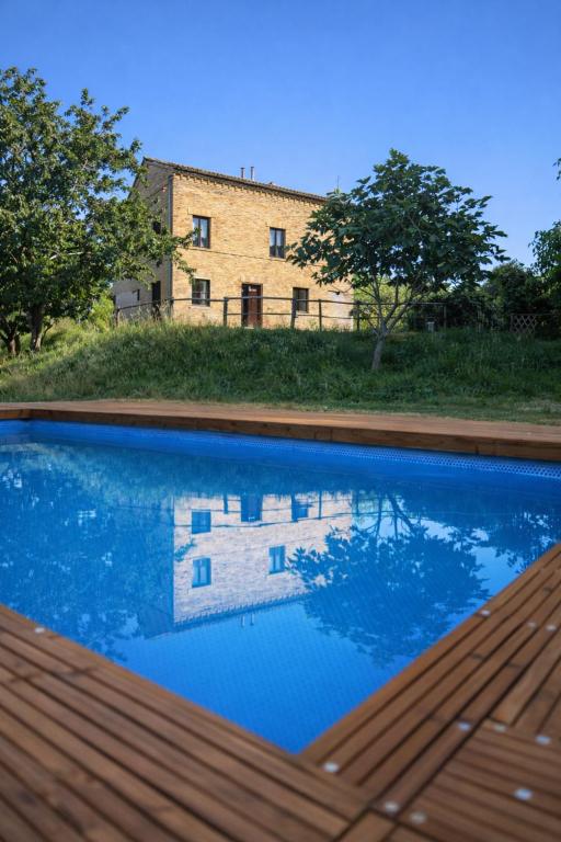 a swimming pool in front of a building at Tenuta Gran Bosco in Loro Piceno