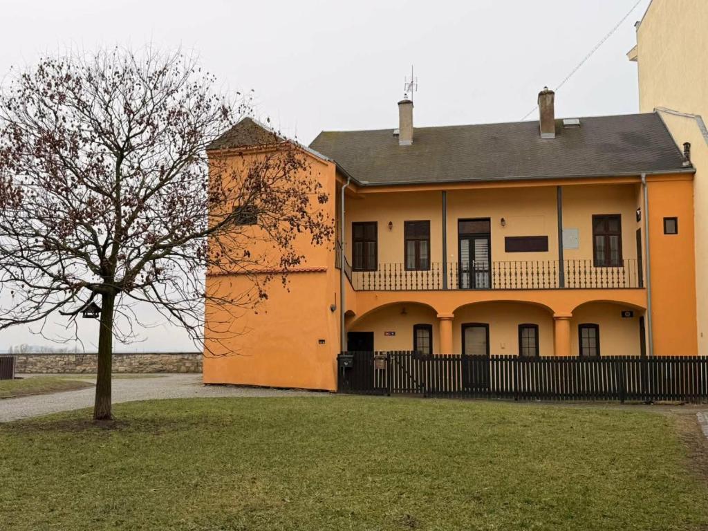 an orange building with a tree in front of it at Parkány Litoměřice in Litoměřice