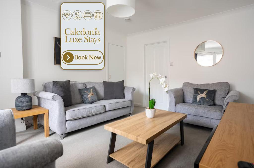 a living room with two couches and a table at Stirling Street Stays in Tillicoultry