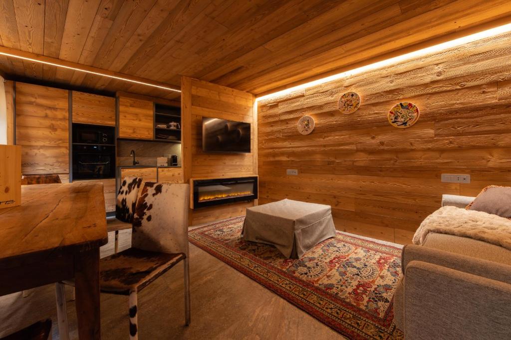 a living room with wooden walls and a couch and a table at Maisons Grandes Murailles-Luxury apartments in Valtournenche