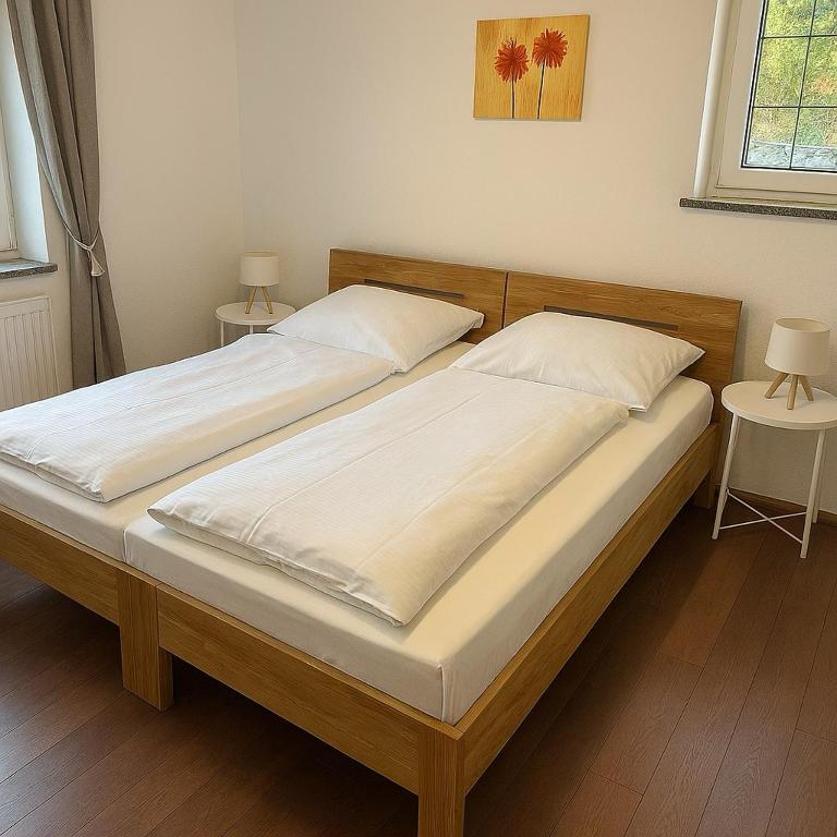 two twin beds in a bedroom with two tables at Westerwald Apartments - Das große Ferienhaus, zentral und ruhig, einfach gut! in Heiligenroth