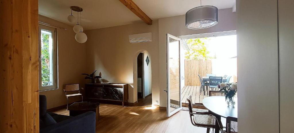 a living room with a table and a dining room at La Maison de Jeanne in Narbonne