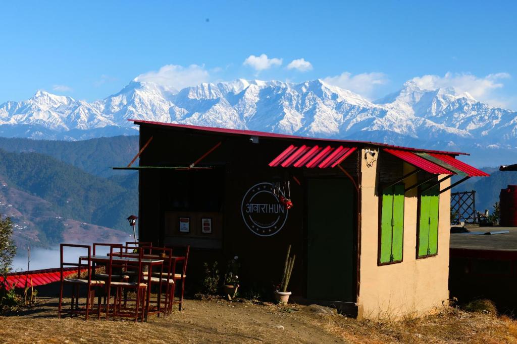 a restaurant with tables and chairs in front of mountains at Traveller Hive Kasar Devi in Almora