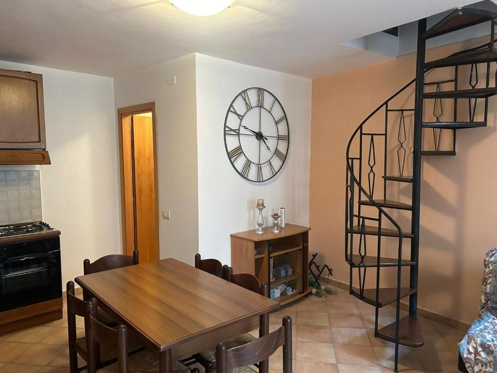a dining room with a table and a clock on the wall at Ferienhaus Casa Silenzio in Mandatoriccio