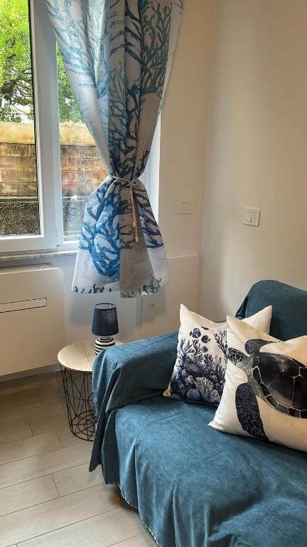 a living room with a blue couch and a window at Casa Conchiglia 6 ospiti 5 minuti a piedi da mare, centro e stazione comfort completo in Rapallo