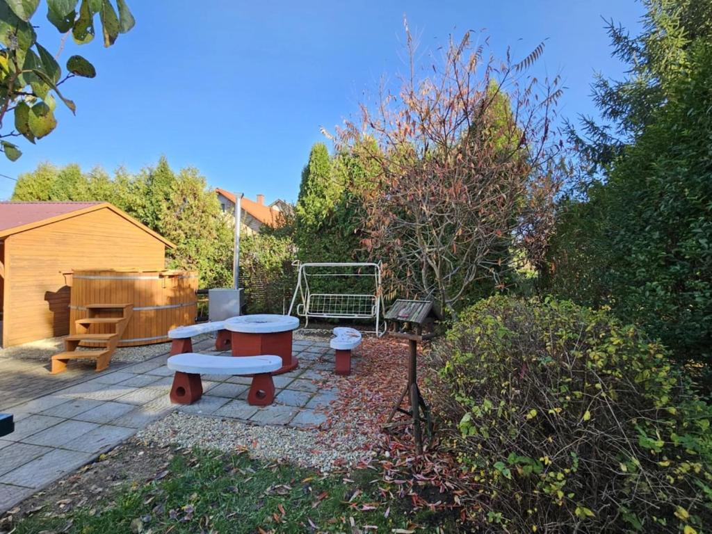 a garden with a bench and a table and a grill at Bányász Vendégház in Csokvaomány