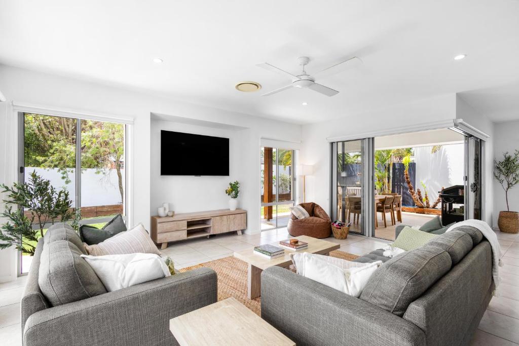 a living room with two couches and a tv at Mooloolaba Parkway Palms Spacious 3BR with Patio & BBQ Pet-Friendly near the Beach in Mooloolaba