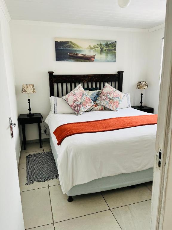 a bedroom with a bed with pillows and a painting at Covenant Place in Cape Town