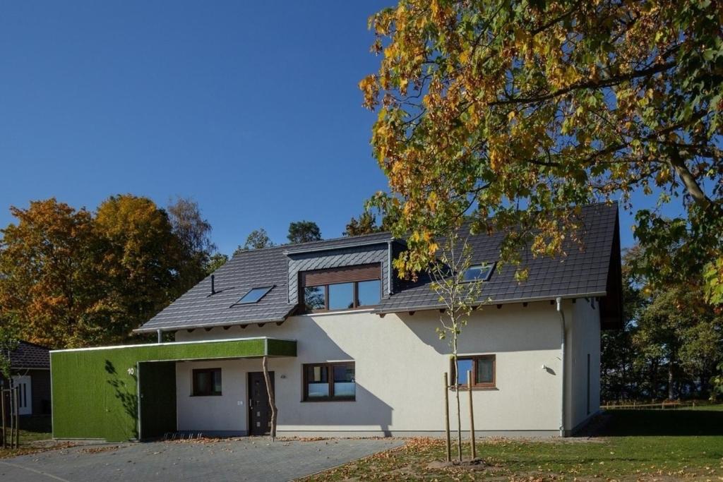 a white house with a black roof at Seehaus in Lenz