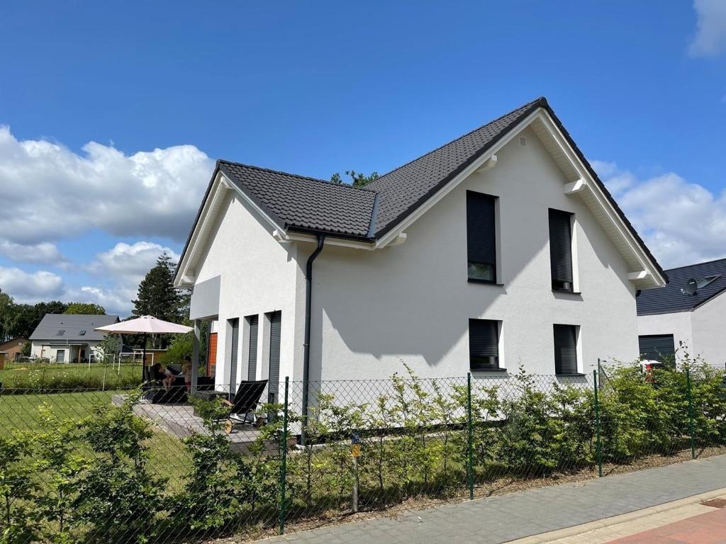 a white house with a black roof at Seemöwe in Lenz