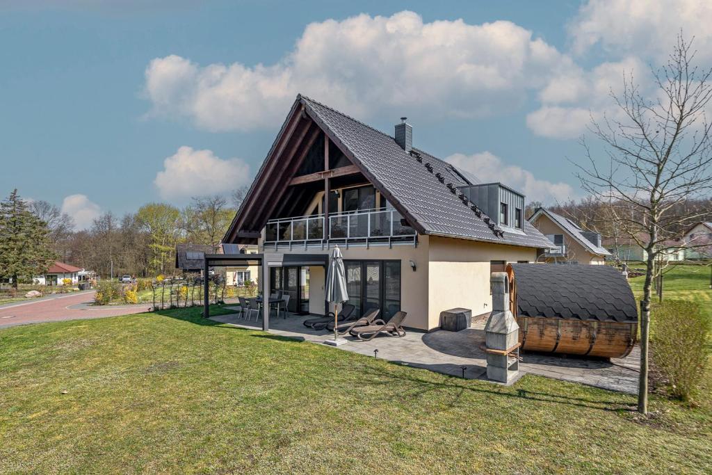 a large house with a gambrel roof and a yard at Lago EG in Lenz