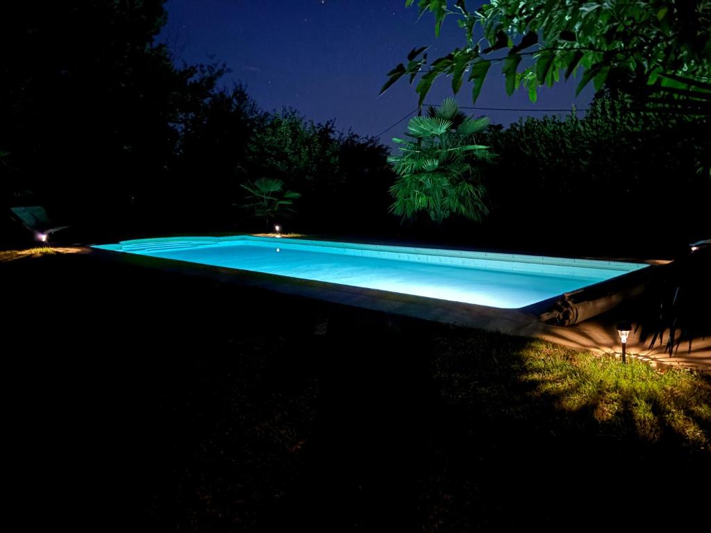 a swimming pool in a yard at night at Aux 12 instants, Imagine in Lédergues