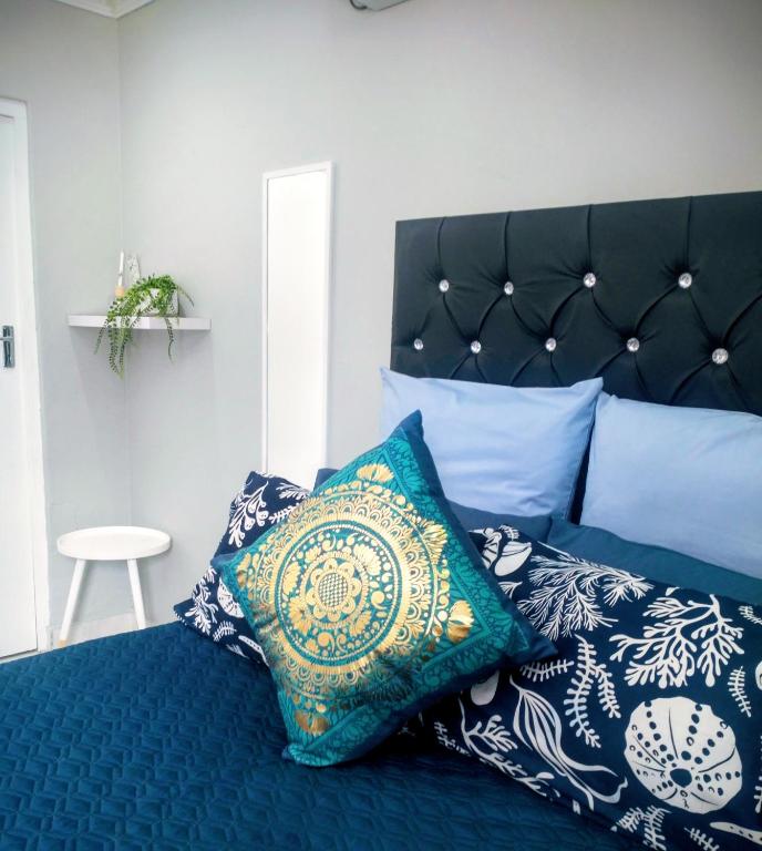 a bedroom with a blue bed with pillows on it at Roxy's in Richards Bay