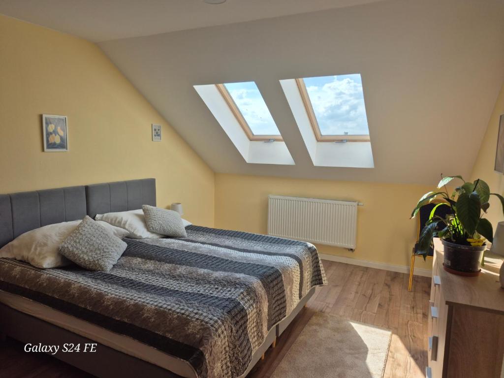 a bedroom with a bed with two skylights at Gościniec Chmielnicki in Chmielnik