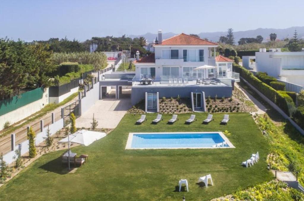 an aerial view of a house with a swimming pool at PG - Beach House in Sintra