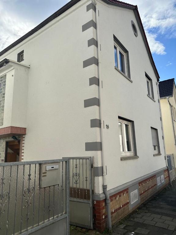 a white building with a fence in front of it at Frankfurt Airport & Fair Apartment in Kelsterbach