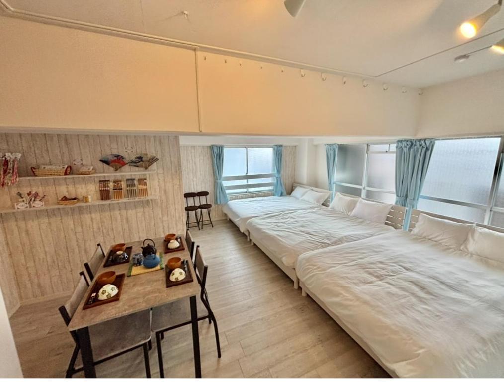 a large bed in a room with a table and chairs at HOTTOSTAYman401 in Sasashimachō