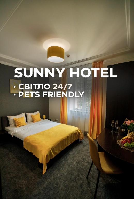 a hotel room with a bed with a yellow blanket at Sunny Hotel in Lviv