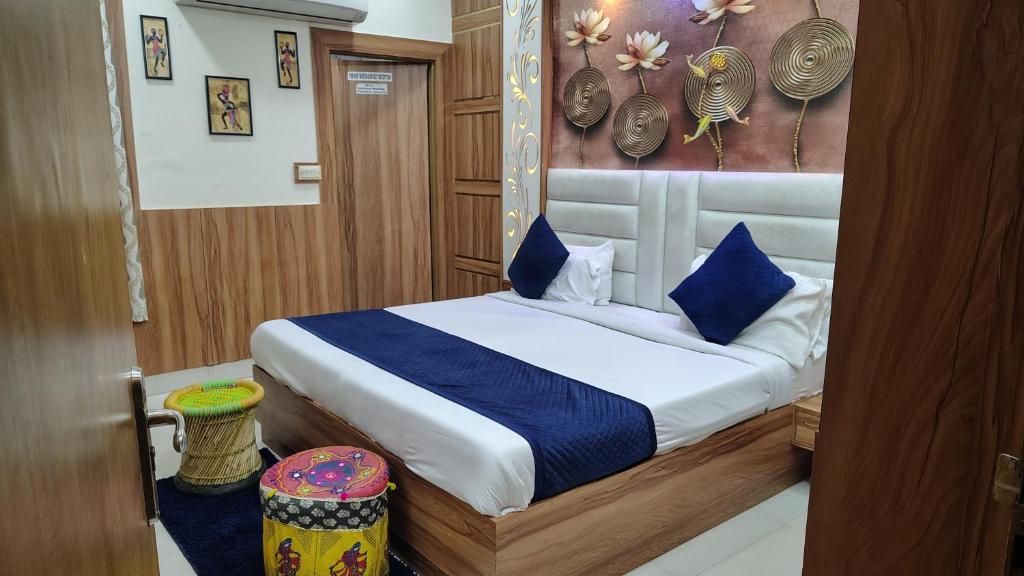a bedroom with a bed with blue pillows and a painting at Bedweiser Backpackers Hostel in Agra