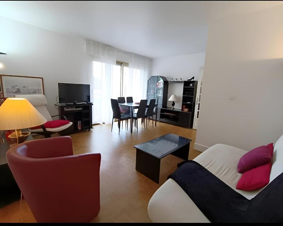 a living room with a couch and a table at La Précieuse, RER A Proche Paris in Saint-Maur-des-Fossés