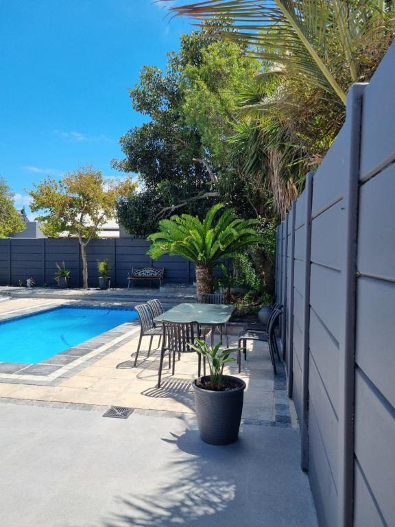 a patio with a table and chairs next to a pool at Frankie's Nest in Cape Town