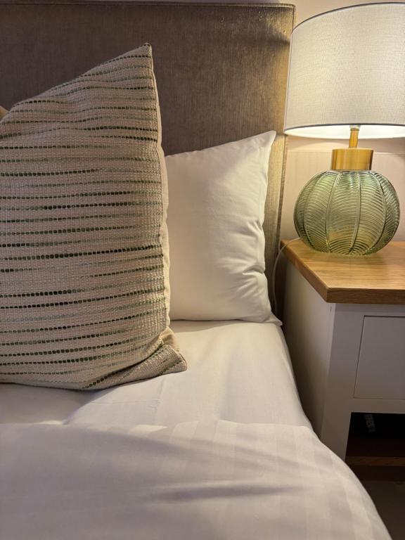 a bed with a pillow and a lamp on a nightstand at The Hare and Hounds in Fulbeck