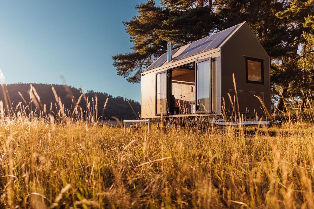 a tiny house sitting in a field of tall grass at Glamping Silverboy in Toužim