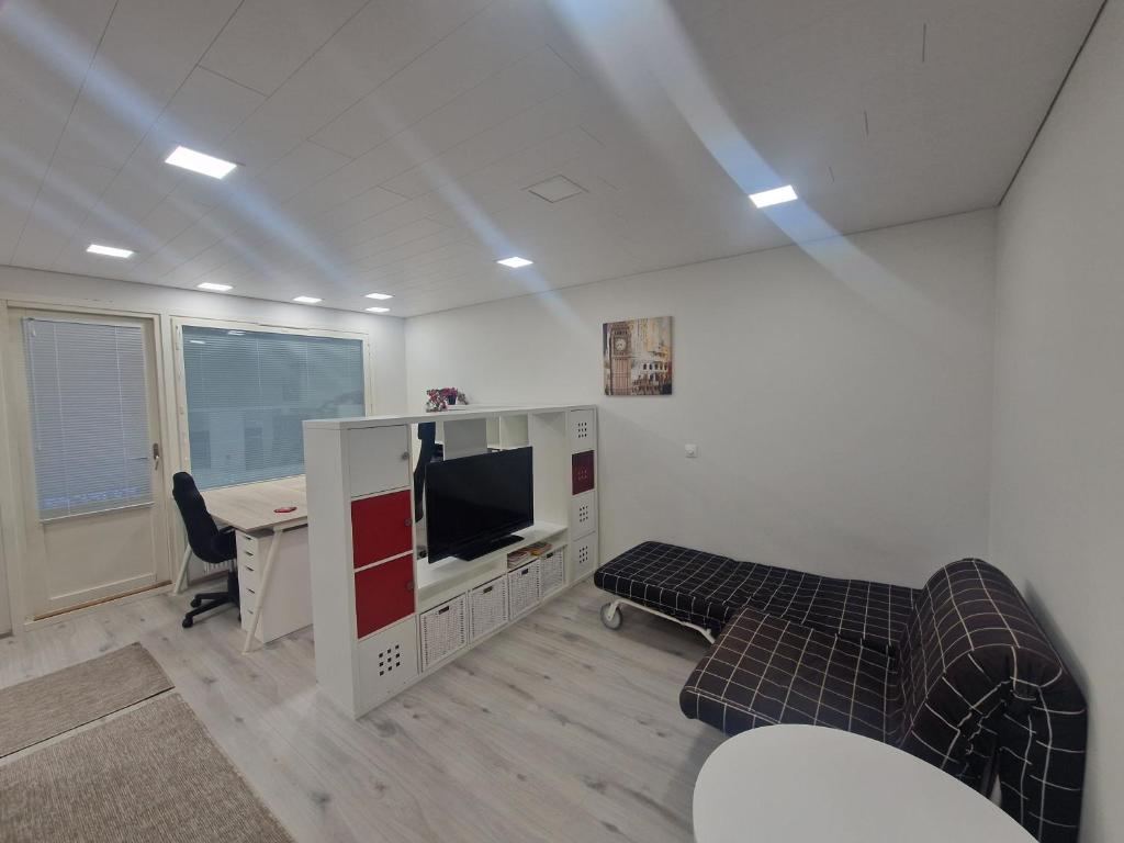 an office with a desk and a tv and a couch at Haltijanmetsä in Kotka